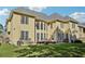 Large backyard with well-kept lawn, patio furniture, and the multiple-windowed facade of a two-story home at 2909 Everson Ridge Ct, Snellville, GA 30039