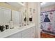 Well-lit bathroom featuring a large mirror, white cabinets, and a charming shower curtain at 2909 Everson Ridge Ct, Snellville, GA 30039