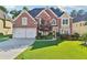 Beautiful brick home with a well-manicured front yard, two-car garage, and elegant landscaping at 2909 Everson Ridge Ct, Snellville, GA 30039