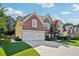 Charming brick home featuring a well-manicured lawn and a two-car garage, set under a bright, partly cloudy sky at 2909 Everson Ridge Ct, Snellville, GA 30039