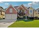 Charming brick home featuring a well-manicured lawn and a two-car garage, set under a bright, partly cloudy sky at 2909 Everson Ridge Ct, Snellville, GA 30039