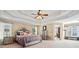 Spacious main bedroom featuring a tray ceiling, ceiling fan, and ensuite bathroom access at 2909 Everson Ridge Ct, Snellville, GA 30039