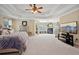 Spacious main bedroom boasts a fireplace, large TV, and neutral carpeting at 2909 Everson Ridge Ct, Snellville, GA 30039