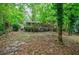 A leafy backyard with a stone pathway leading to a brick home with a wooden deck at 3294 Francine Dr, Decatur, GA 30033