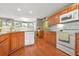 Well-lit kitchen features granite countertops, wood cabinets and white appliances with a tile backsplash at 60 Heaton Dr, Covington, GA 30016
