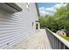 Back deck showcasing grey wooden planks plus railings overlooking a treed lawn at 8464 Pleasant Hill Rd, Lithonia, GA 30058