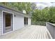 Back deck showcasing grey wooden planks plus railings overlooking a treed lawn at 8464 Pleasant Hill Rd, Lithonia, GA 30058