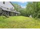 Large backyard with deck, mature trees, and shed, offering privacy and outdoor space at 8464 Pleasant Hill Rd, Lithonia, GA 30058