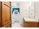 Bathroom with a single sink vanity, wood cabinets, and a window with natural light at 8464 Pleasant Hill Rd, Lithonia, GA 30058