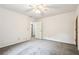 Bedroom showcasing a ceiling fan, door, and open entry, plus neutral walls and carpet flooring at 8464 Pleasant Hill Rd, Lithonia, GA 30058