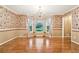 Formal dining room with hardwood floors, large windows, chandelier, and elegant wall paper at 8464 Pleasant Hill Rd, Lithonia, GA 30058