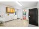 Laundry room with tile floors, a utility sink, storage cabinets, and patterned wallpaper at 8464 Pleasant Hill Rd, Lithonia, GA 30058