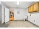 Laundry room with tile floors, a utility sink, overhead storage, and colorful wallpaper at 8464 Pleasant Hill Rd, Lithonia, GA 30058