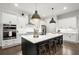 Modern kitchen with white cabinets, stainless steel appliances, a large island with seating, and pendant lighting at 124 Calder Dr, Alpharetta, GA 30009