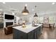 Bright kitchen with a central island, with pendant lights and the view to the Gathering room with a fireplace at 124 Calder Dr, Alpharetta, GA 30009