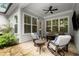 Inviting outdoor patio featuring a stone floor, a ceiling fan, comfortable seating, and wooded view at 124 Calder Dr, Alpharetta, GA 30009