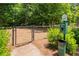 Community pet waste station with a sign and waste bag dispenser in a fenced green space at 124 Calder Dr, Alpharetta, GA 30009