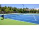 A community tennis court featuring a bright blue playing surface, set amidst a backdrop of lush trees at 124 Calder Dr, Alpharetta, GA 30009