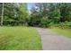 Long paved driveway leading to a tree-lined property with white fence at 1368 Tommy Lee Cook Rd, Palmetto, GA 30268