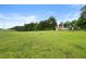 Expansive grassy field with scattered trees and distant buildings at 1368 Tommy Lee Cook Rd, Palmetto, GA 30268