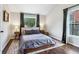 Well-lit bedroom boasts hardwood floors, two side tables, and a large window at 3036 Horse Shoe Se Dr, Atlanta, GA 30316