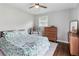 Comfortable bedroom features a ceiling fan, dresser, and stylish leaf-pattern bedding at 3036 Horse Shoe Se Dr, Atlanta, GA 30316