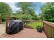 Relaxing outdoor deck featuring wood railings, a grill, and lovely green surroundings at 3036 Horse Shoe Se Dr, Atlanta, GA 30316