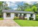 Ranch home with green lawn, walkway, and driveway is freshly painted and landscaped at 3036 Horse Shoe Se Dr, Atlanta, GA 30316