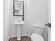 Cozy bathroom with a classic pedestal sink, dark wood floors and decorative mirror at 5668 Union Pointe Dr, Union City, GA 30291
