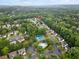 A high-angle shot of a community pool and tennis courts nestled among verdant trees and well-kept homes at 10795 Glenbarr Dr, Johns Creek, GA 30097