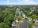 An aerial view of a residential area, lined with trees, showcasing homes with manicured lawns and paved driveways at 10795 Glenbarr Dr, Johns Creek, GA 30097