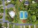Aerial shot showcasing a community pool and tennis courts bordered by manicured landscaping and lush trees at 10795 Glenbarr Dr, Johns Creek, GA 30097