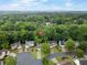 An aerial view of a neighborhood showcasing the homes nestled within a dense, green canopy of trees at 10795 Glenbarr Dr, Johns Creek, GA 30097