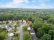 Wide aerial shot of a lush, green suburban neighborhood, showcasing well-kept homes under a cloudy sky at 10795 Glenbarr Dr, Johns Creek, GA 30097