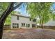 View of the back of the house from a tree-lined yard with wood fence at 10795 Glenbarr Dr, Johns Creek, GA 30097