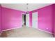 Bright bedroom features pink walls, neutral carpet and a door leading to the hallway at 10795 Glenbarr Dr, Johns Creek, GA 30097