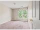 Bedroom with tan carpet features natural light from a large window with a treed view at 10795 Glenbarr Dr, Johns Creek, GA 30097