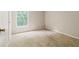 Neutral bedroom features tan carpet and natural light from a window with a treed view at 10795 Glenbarr Dr, Johns Creek, GA 30097