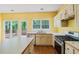 Open concept kitchen with island, white cabinets, hard surface flooring and stainless appliances at 10795 Glenbarr Dr, Johns Creek, GA 30097