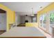 Eat-in kitchen with bright yellow walls and an opening into the living room with a fireplace at 10795 Glenbarr Dr, Johns Creek, GA 30097
