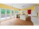 Eat-in kitchen with white cabinets, island and a view of the back yard at 10795 Glenbarr Dr, Johns Creek, GA 30097