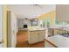 Kitchen with an island, white cabinetry, view to the living room and stainless steel appliances at 10795 Glenbarr Dr, Johns Creek, GA 30097