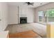Living room with fireplace, ceiling fan, large window and combination of hard surface and carpet flooring at 10795 Glenbarr Dr, Johns Creek, GA 30097