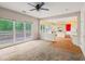 Living room with large window, ceiling fan and combination of hard surface and carpet flooring at 10795 Glenbarr Dr, Johns Creek, GA 30097