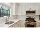 Well-lit kitchen featuring quartz countertops, stainless steel appliances, and white cabinetry at 1245 S Ponce De Leon Ne Ave # 13, Atlanta, GA 30306