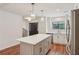Modern kitchen boasts white cabinets, a stainless steel fridge, an island, and hardwood floors at 1245 S Ponce De Leon Ne Ave # 13, Atlanta, GA 30306