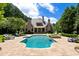 Expansive backyard featuring a sparkling pool, spa, and meticulously manicured greenery at 3639 Paper Mill Se Rd, Marietta, GA 30067