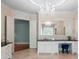 Bathroom has an elegant chandelier over vanity with granite counters and white cabinets at 3639 Paper Mill Se Rd, Marietta, GA 30067