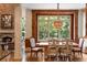 Bright dining area with stone fireplace, wood framed windows, and chandelier lighting at 3639 Paper Mill Se Rd, Marietta, GA 30067