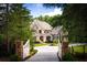 Stunning home with a long driveway, stone columns, white gates, and a mix of brick, stone and gray wood facade at 3639 Paper Mill Se Rd, Marietta, GA 30067